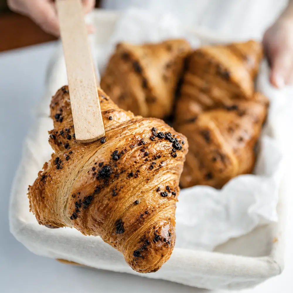 Croissant de chocolate con topping crujiente de Valumé Catering.